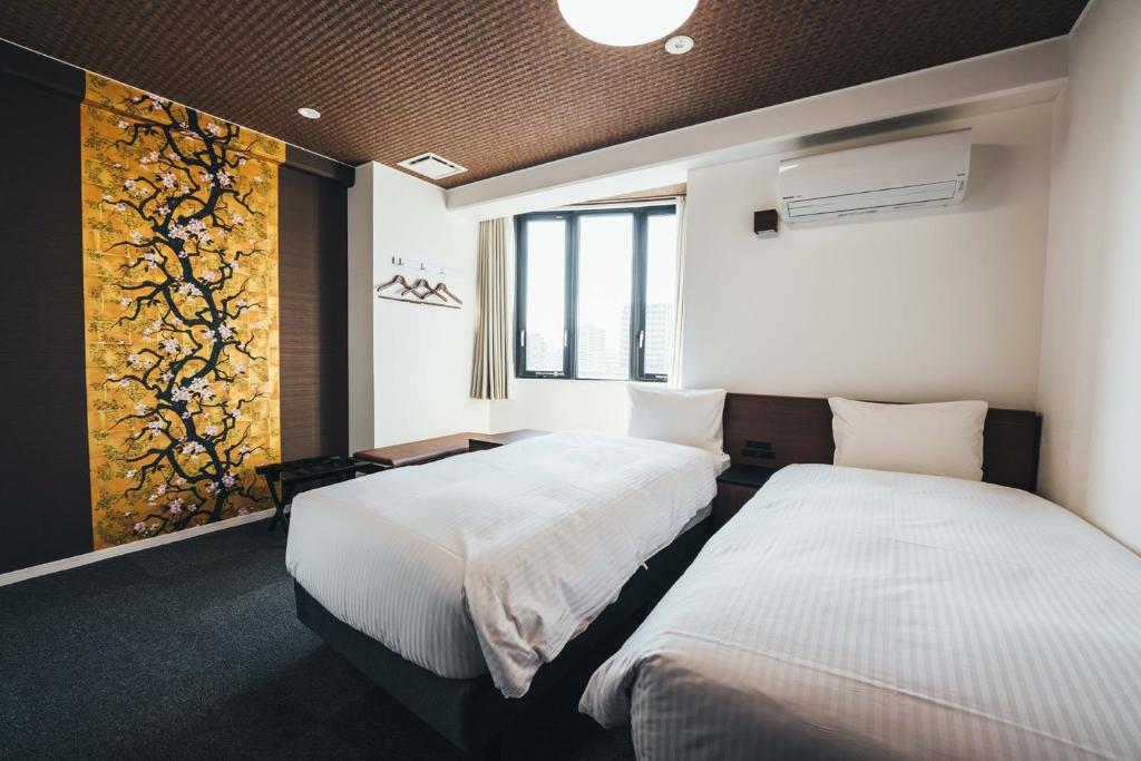 佐賀市にあるTAPSTAY HOTEL - Vacation STAY 35230vのベッドルーム1室(ベッド2台付)が備わります。壁には絵画が飾られています。