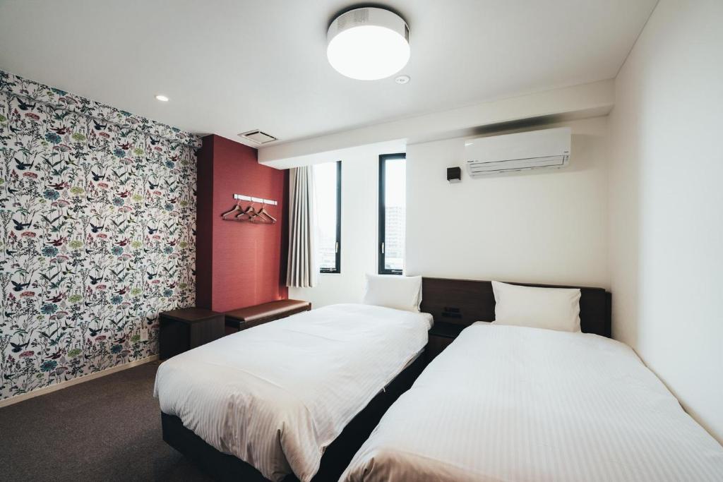 two beds in a room with red walls at TAPSTAY HOTEL - Vacation STAY 35235v in Saga