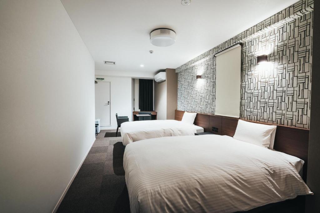 佐賀市にあるTAPSTAY HOTEL - Vacation STAY 35203vのベッド2台と鏡が備わるホテルルームです。