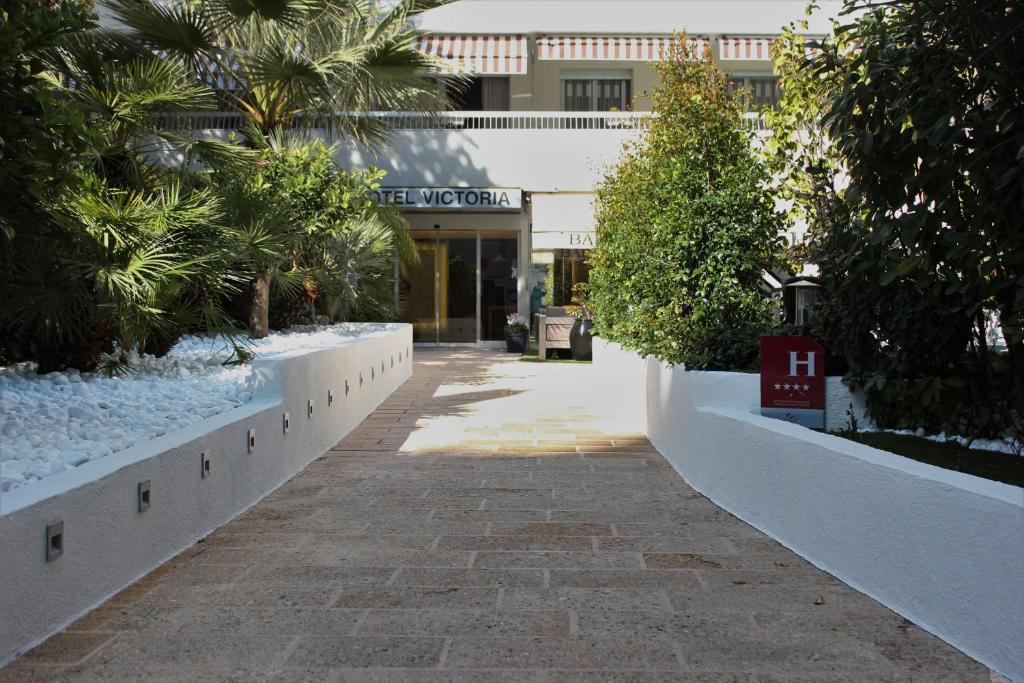 a walkway in front of a building with plants at Hôtel Victoria in Cannes