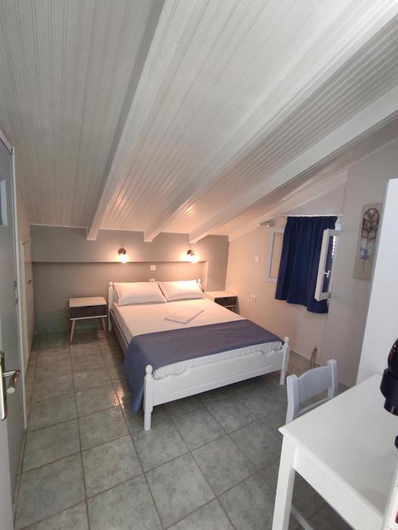 a bedroom with a bed and a white ceiling at Venus Rooms in Katelios