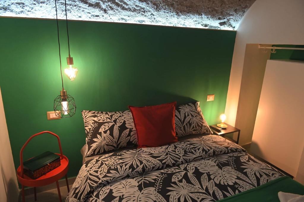 una camera verde con un letto e una parete verde di Mini Loft Regina Elena a Torre Annunziata