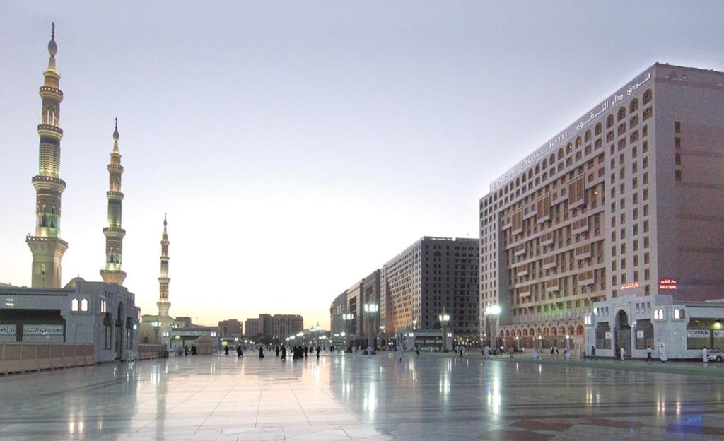 メディナにあるダル アル タクワ ホテルの高い建物とモスクのある街
