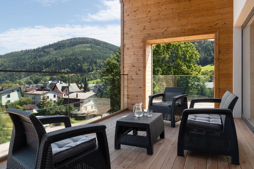 balcone con sedie, tavoli e vista sulle montagne di Novy Szczyrk Centrum - Aparthotel z sauną - Dream Apart a Szczyrk