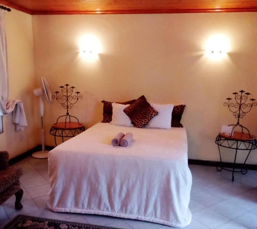 ein Schlafzimmer mit einem Bett mit zwei Kerzen darauf in der Unterkunft Copperbelt Executive Accommodation Ndola, Zambia in Ndola