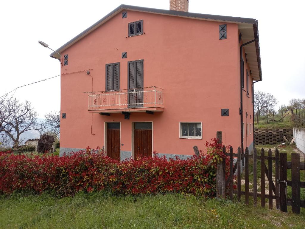 an orange house with a balcony on top of it at CASA VACANZA POLI in Ascoli Piceno