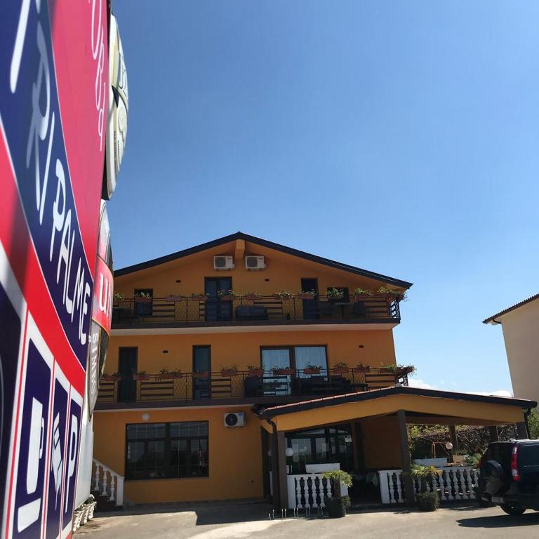 a yellow building with balconies on the side of it at Sobe ROOMS TEA in Buje