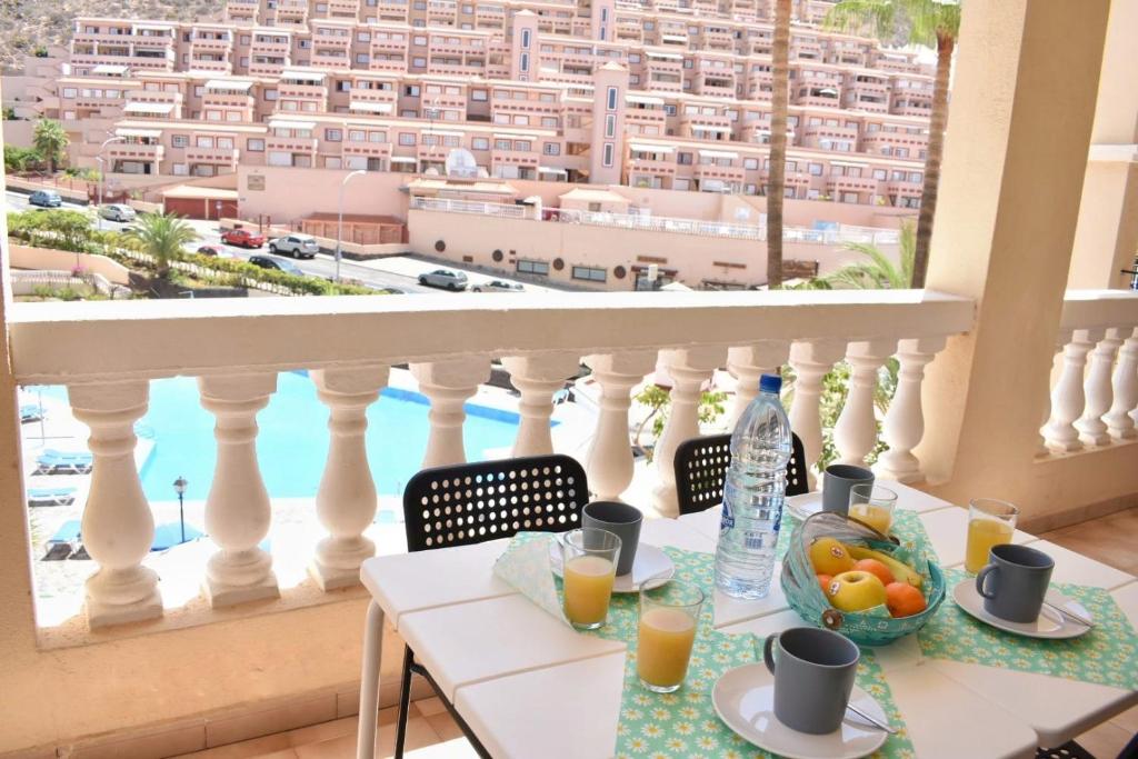 un tavolo con prodotti per la colazione e una vista sulla città di Castle Margherita's Apartments a Los Cristianos