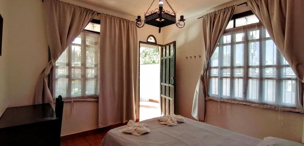 a bedroom with a bed and a large window at Mikaso Hotel in San Pedro La Laguna