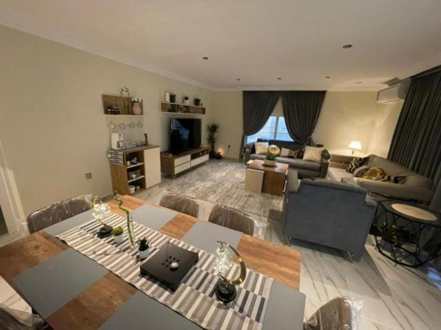uma sala de estar com um sofá e uma mesa em شاليهات 4U vip em Dammam