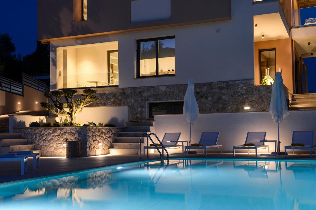 a villa with a swimming pool at night at MARAVILLA SUITES in Kavala