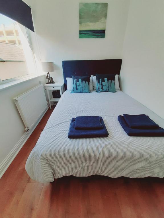 Un dormitorio con una cama con toallas azules. en Cosy 1 Bedroom Apartment in the Heart of Llandudno en Llandudno