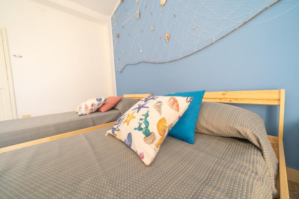 a bed with two pillows and a climbing wall at VICOLO A MARE in Siracusa