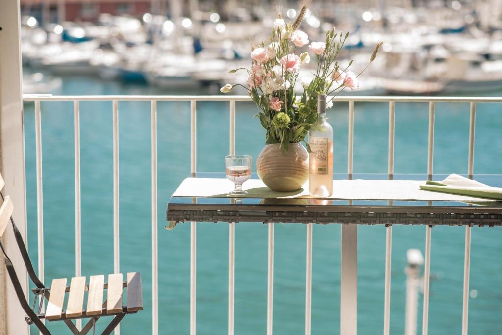 Marinca du Port de Toulon في تولون: طاولة مع إناء من الزهور وكوب من الماء