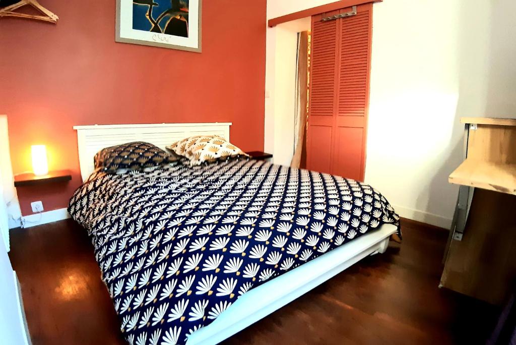 ルマンにあるLa Glacière - chambre avec salle de bain - 2 personnesの赤い壁のベッド1台が備わるベッドルーム1室