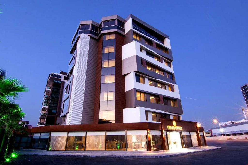 een hoog gebouw met een winkel ervoor bij MAJURA HOTEL BUSINESS in Karşıyaka