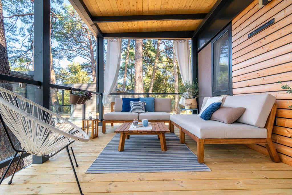 a screened in porch with two couches and a table at Mobile Homes AZZURRO in Rovinj