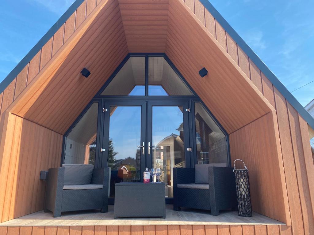 a building with two chairs and a large window at The Big Tiny House in Lurgan