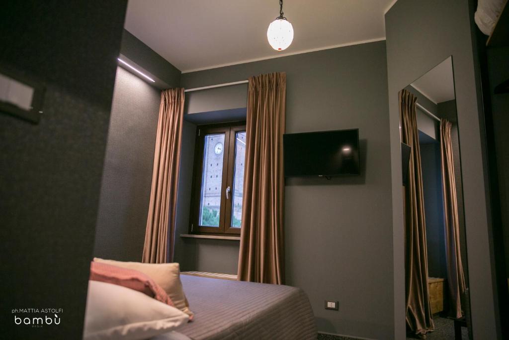 sypialnia z łóżkiem i oknem w obiekcie La Taverna Antica Rooms w mieście Pescara