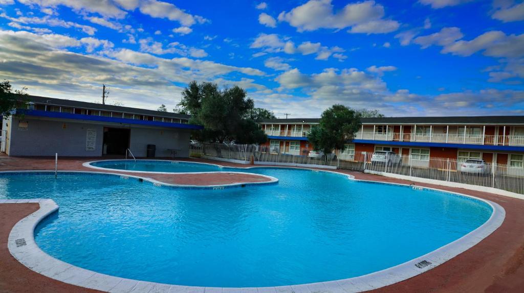 una gran piscina frente a un edificio en La Hacienda Hotel, en Laredo