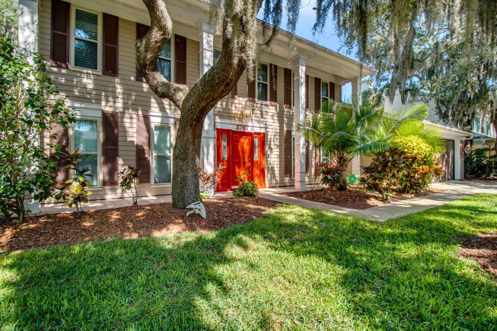 une maison avec un arbre dans la cour avant dans l'établissement Tampa Bay Pool Home with Heated Pool, à Brandon