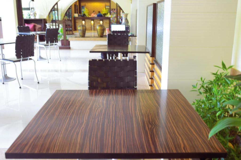 A dark wood table sits beside seating in the hotel’s bright reception area.