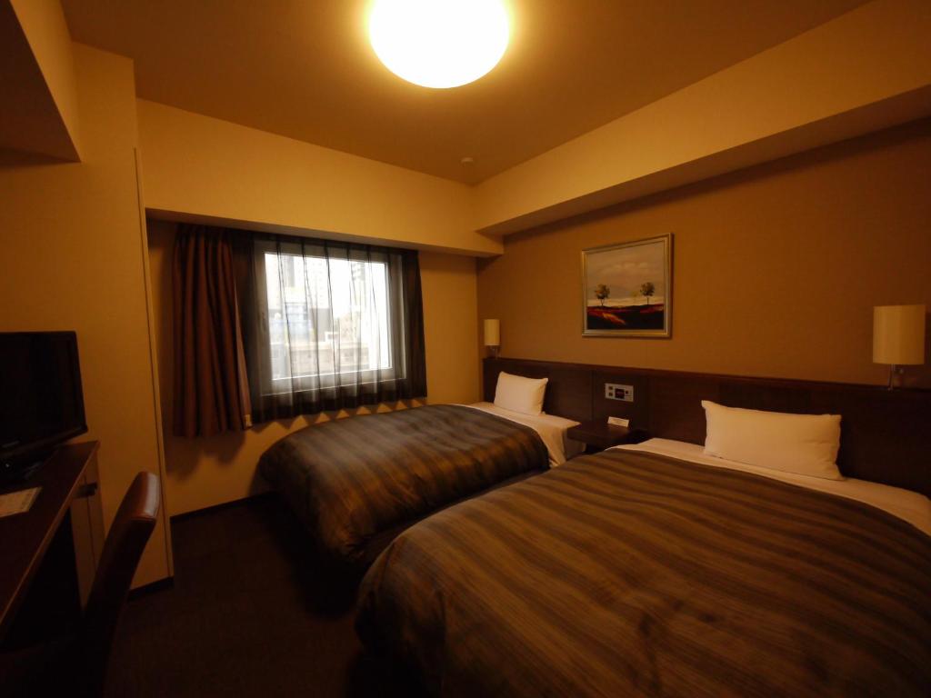 En eller flere senger på et rom på Hotel Route-Inn Nagoya Imaike Ekimae