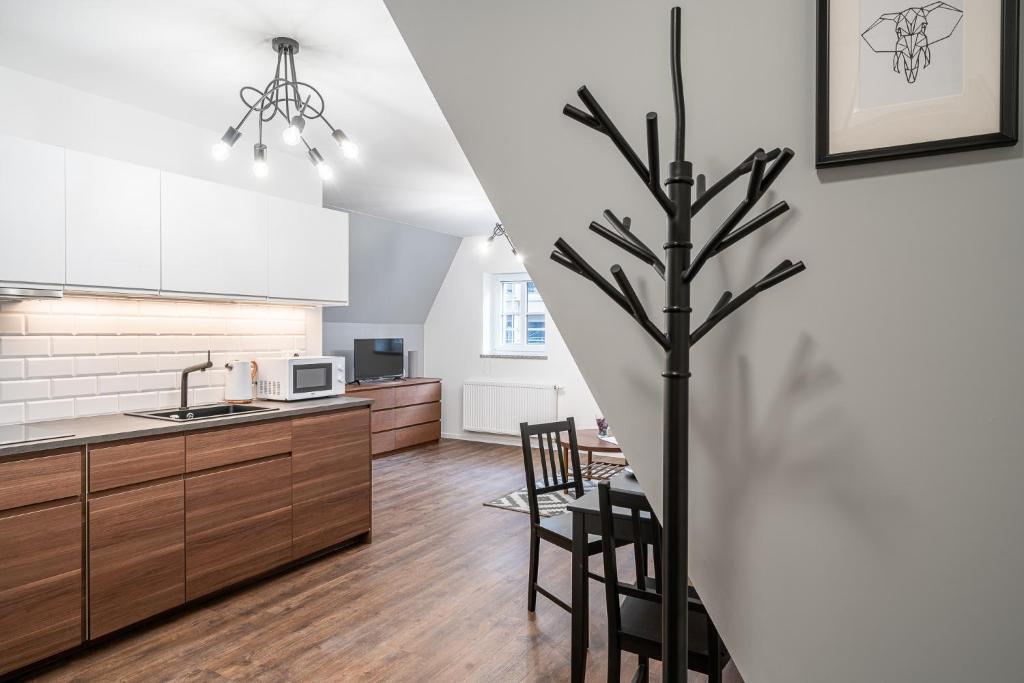 a kitchen with a tree in the middle of a room at ✰Mansarda na Białoskórniczej✰5 minut od Rynku in Wrocław