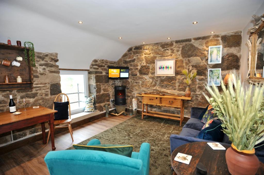 a living room with a stone wall at Beach View in Benllech