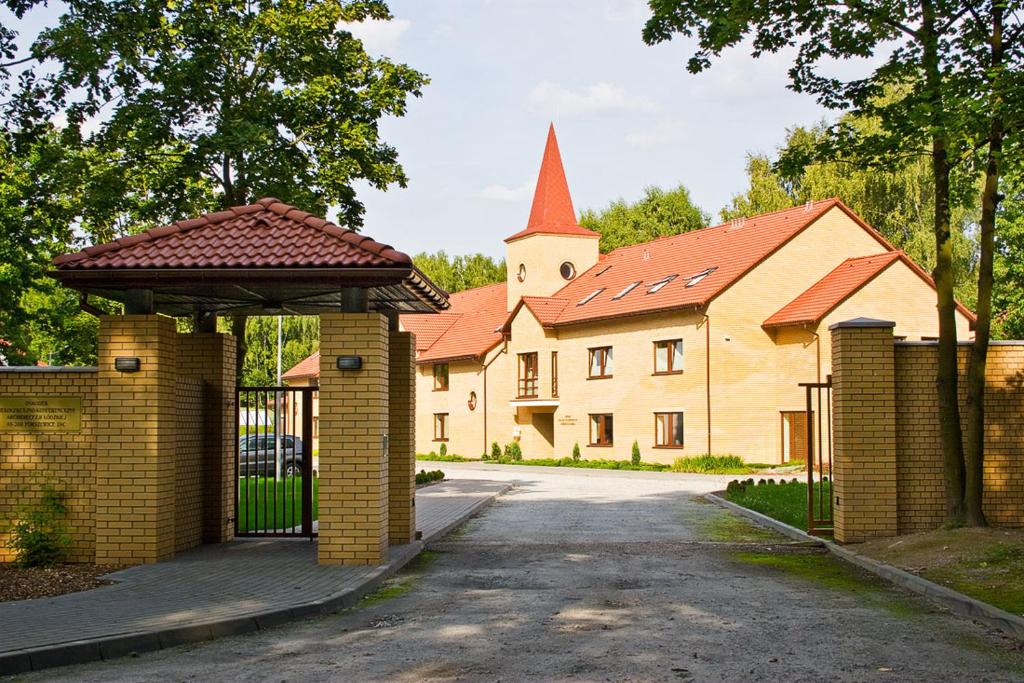 un edificio con una puerta y una iglesia en Uroczysko Porszewice - Ośrodek Konferencyjno-Rekolekcyjny Archidiecezji Łódzkiej, en Pabianice