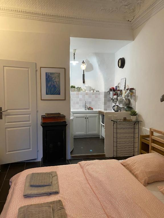 a room with a bed and a kitchen with a counter at Le petit carnot in Apt