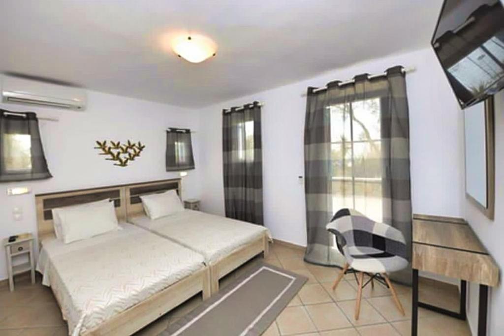 una camera con letto, scrivania e sedia di Sunset 7.59 a Mykonos Città
