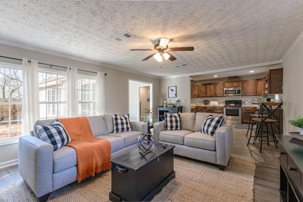 ein Wohnzimmer mit 2 Sofas und einem Deckenventilator in der Unterkunft 4BR Ranch Style Home A Mile From Historic Downtown in Cartersville