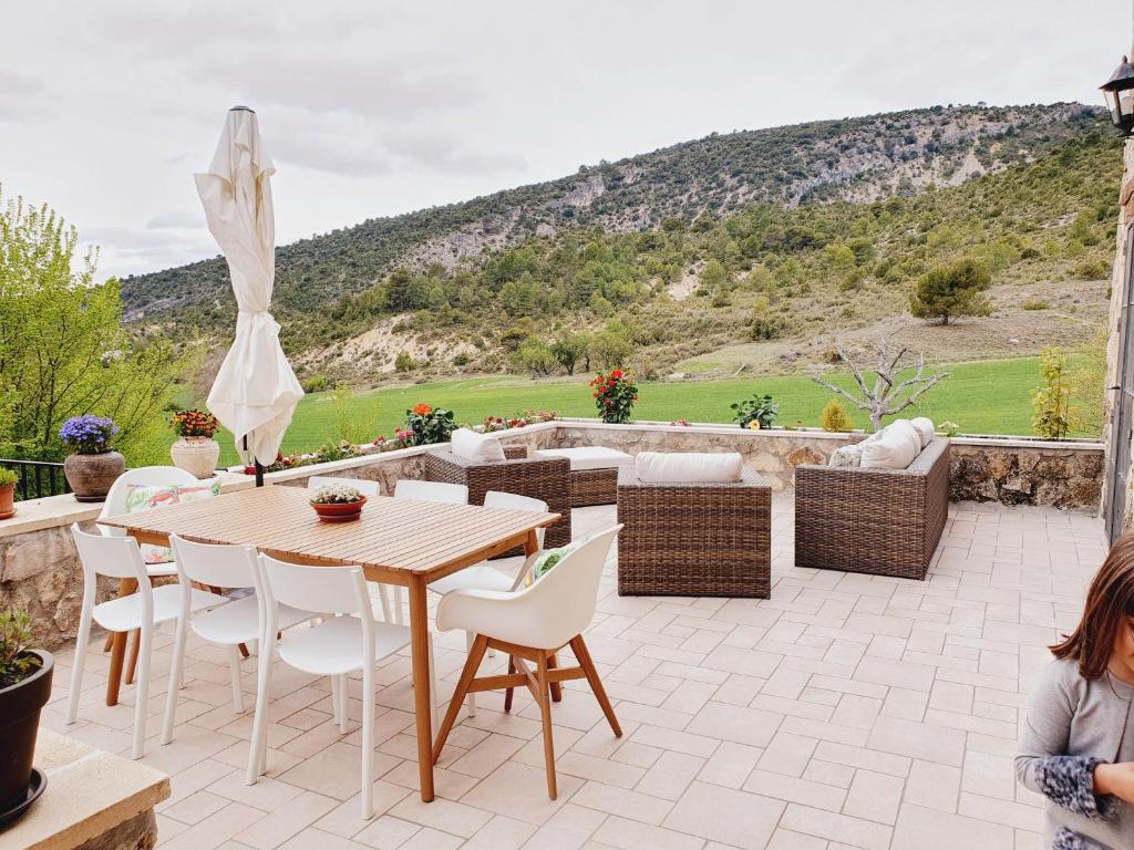 un patio con mesa de madera, sillas y vistas. en El Mirador de Oter, en Oter