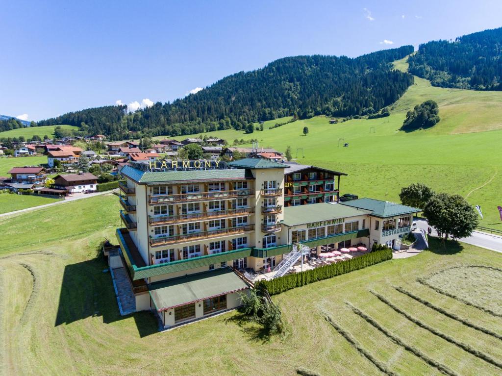 an aerial view of a hotel in a field at Harmony Hotel Harfenwirt in Niederau