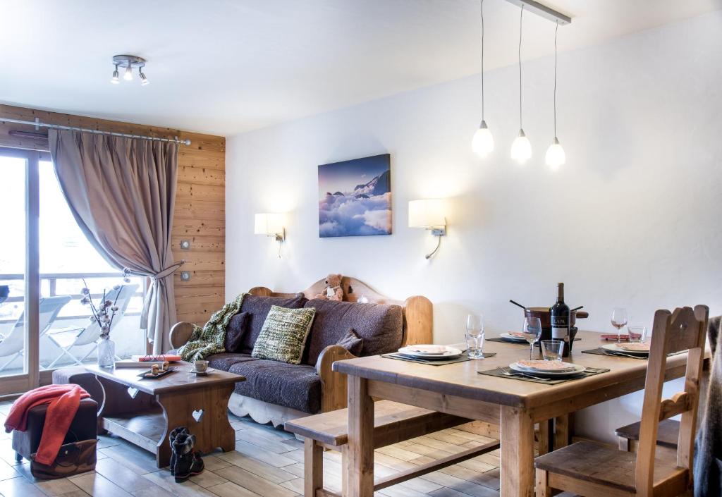 a living room with a couch and a table at Résidence - Les Grandes Alpes in La Clusaz