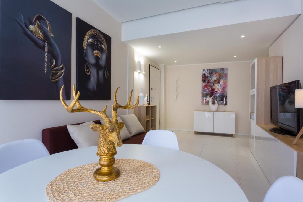 a dining room with a white table with a deer trophy on it at Stesicoro Exclusive House in Catania