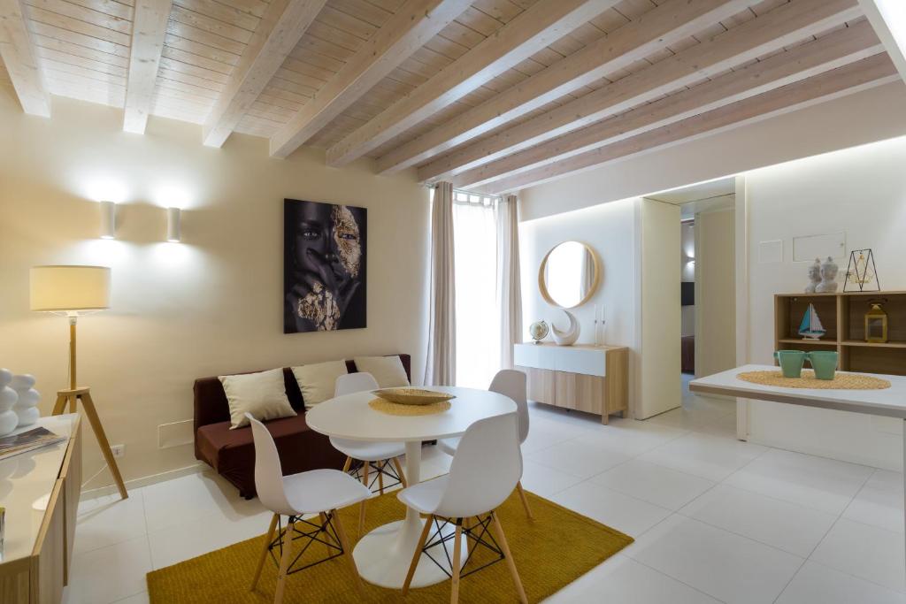 a living room with a couch and a table and chairs at Stesicoro Exclusive House in Catania