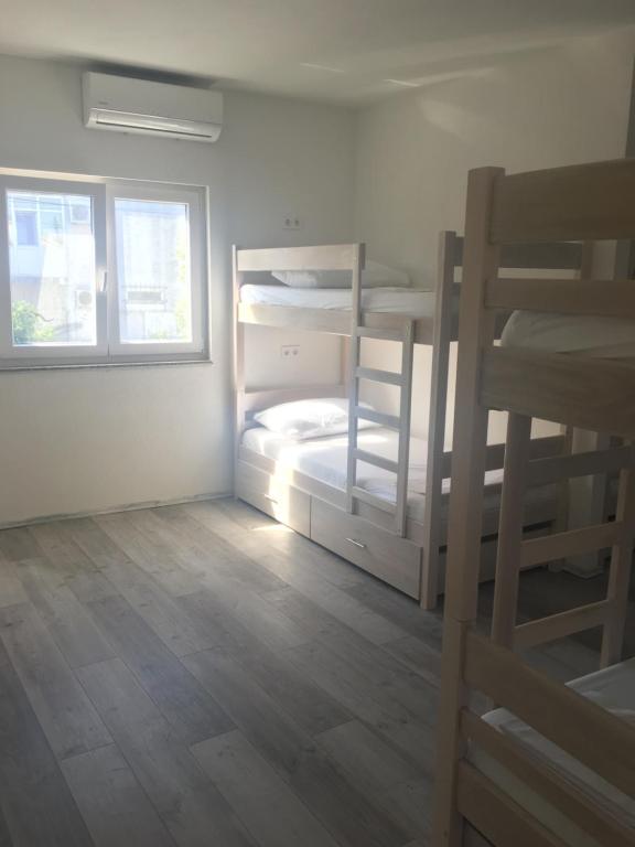 a room with two bunk beds and a window at Backpackers Home in Zadar