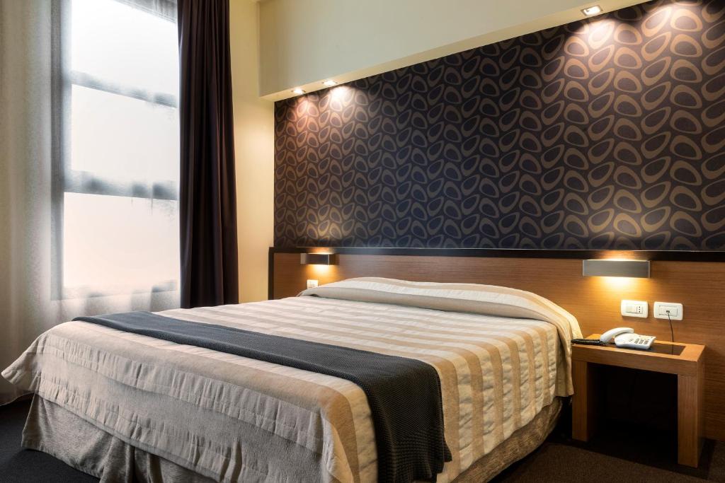 een slaapkamer met een groot bed en een raam bij HC3 Hotel in Bologna