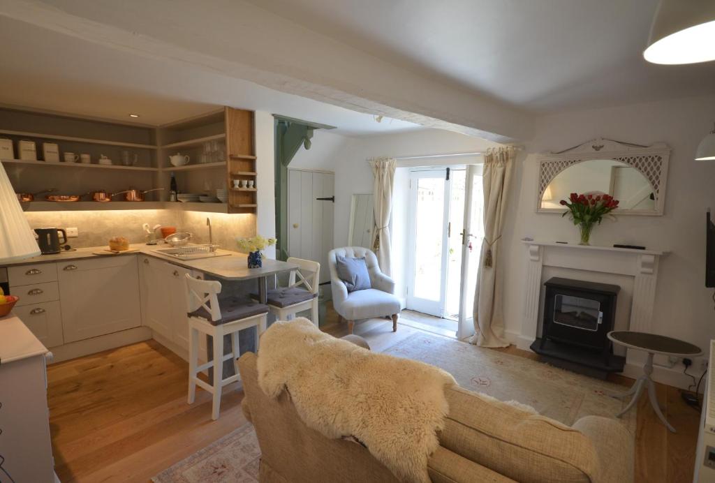 a kitchen and living room with a couch and a fireplace at Wrenscott in Chagford