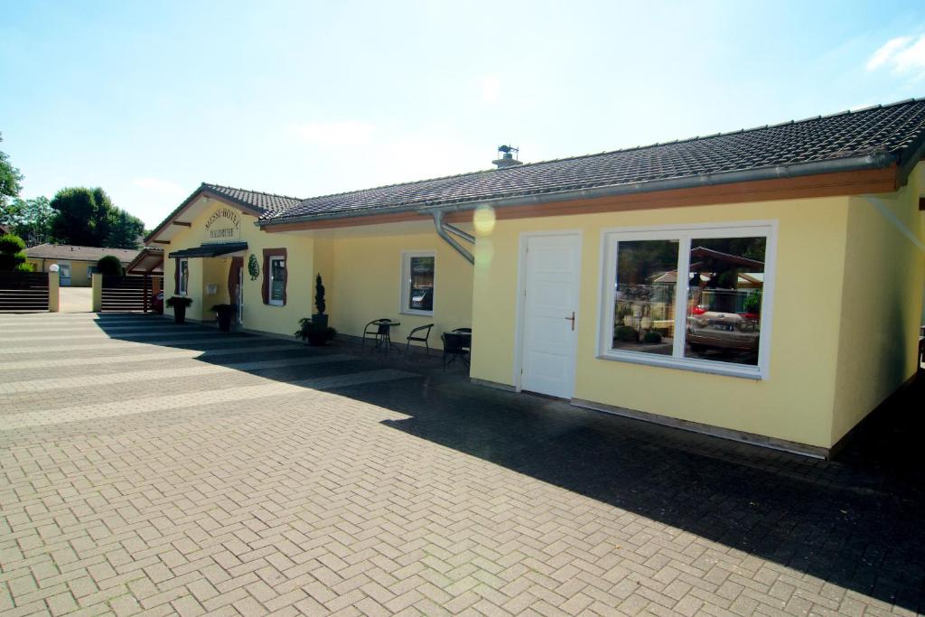 a building with a patio and a building with a window at Messe-Hotel "Waldruhe" in Giesen