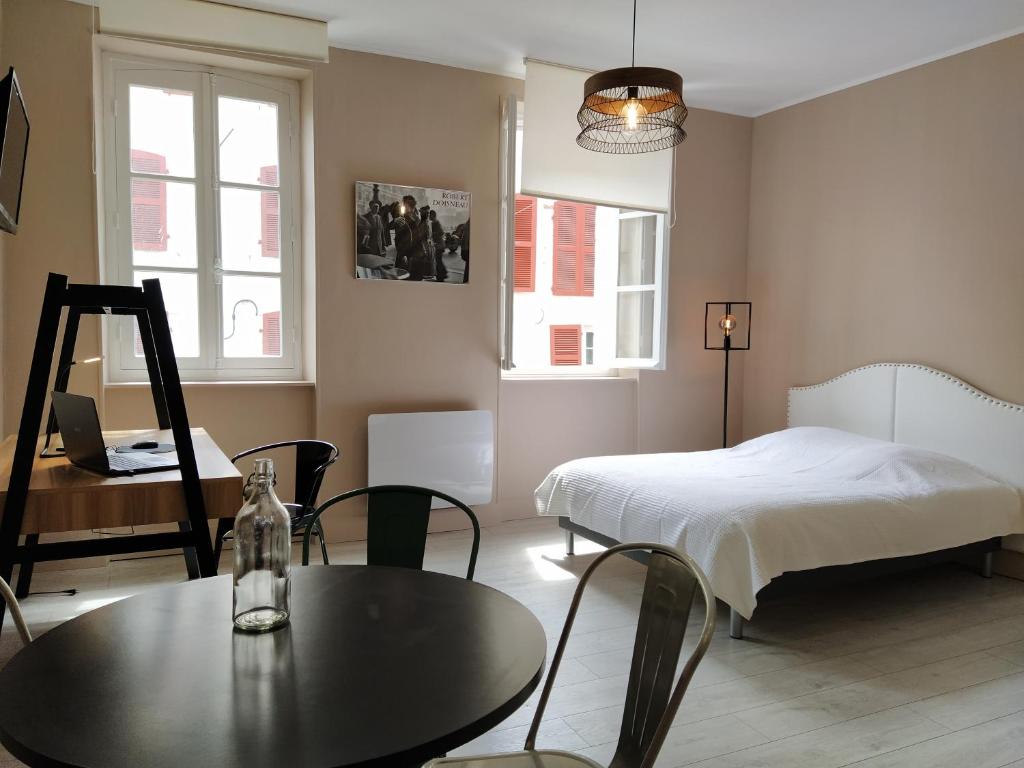 une chambre avec un lit, une table et des chaises dans l'établissement Baiona Sainte Cath -2-BI-, à Bayonne