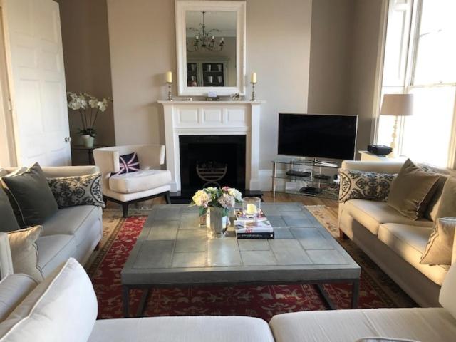 a living room with couches and a coffee table at 1 Georges Place Bath in Bath