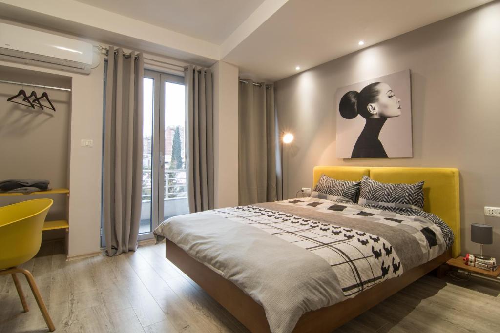 a bedroom with a bed with a yellow headboard at Vanilla Boutique Apartments in Skopje