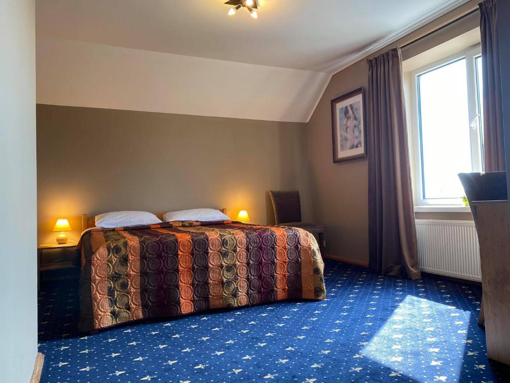 een hotelkamer met een bed en een raam bij Šeduvos malūnas in Šiauliai