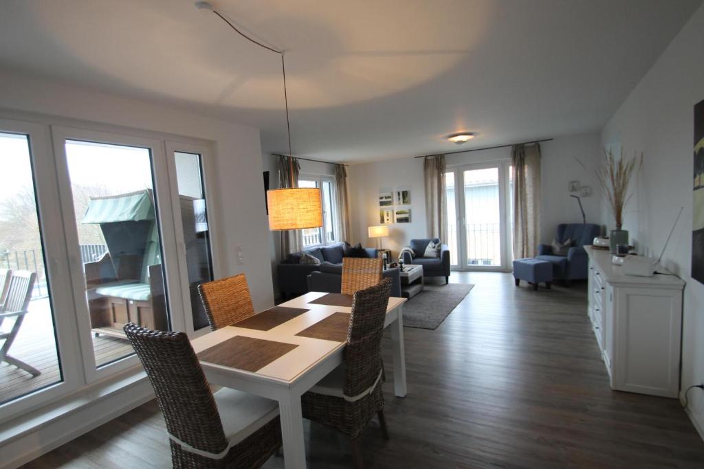 a dining room with a table and chairs and a living room at 1908 - Am Kurpark in Dahme