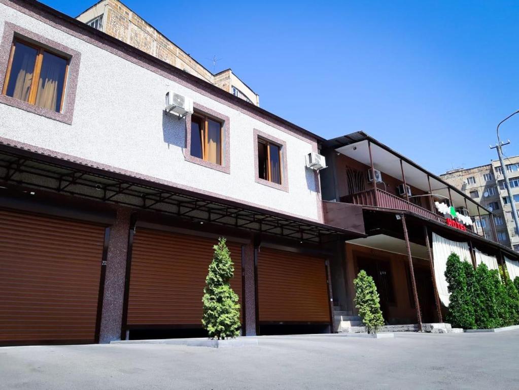a building with two garage doors and a balcony at Green Garden Hotel in Yerevan