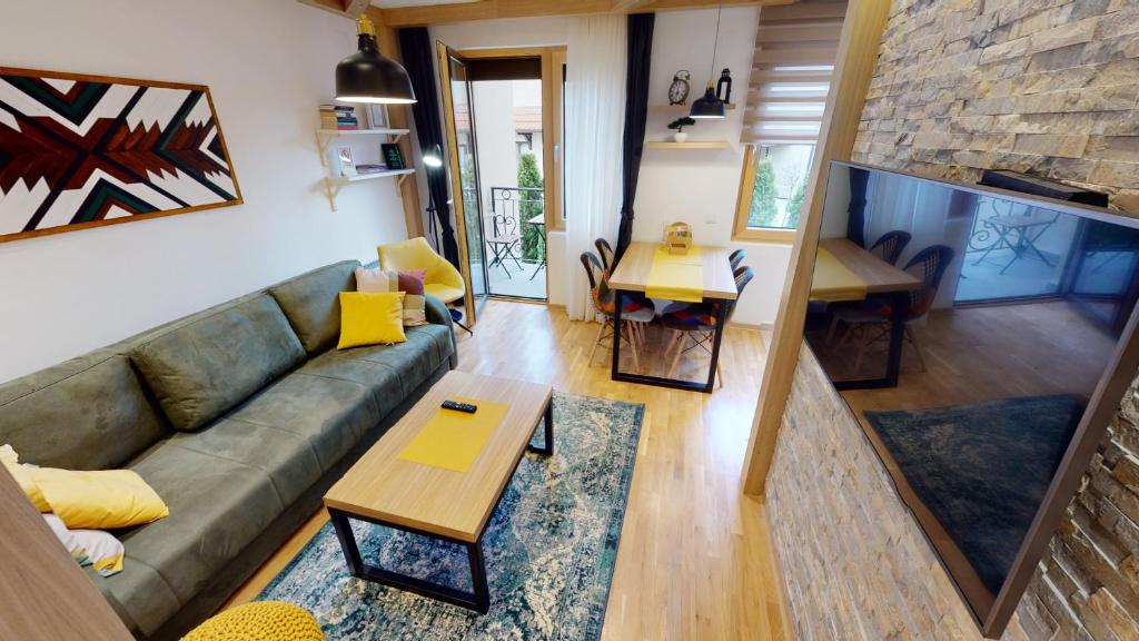 sala de estar con sofá y mesa en Wooden Corner Apartment, en Zlatibor
