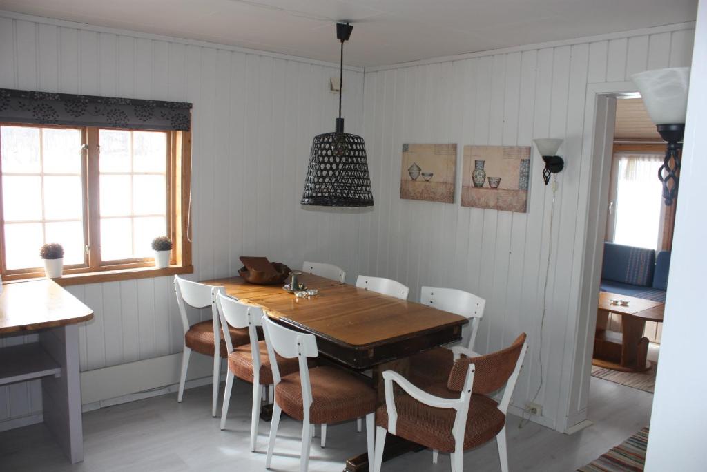 a dining room with a wooden table and chairs at Bustad Hyttetun in Skåbu